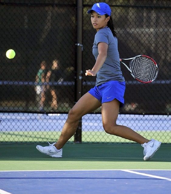 Woman playing tennis running to return ball